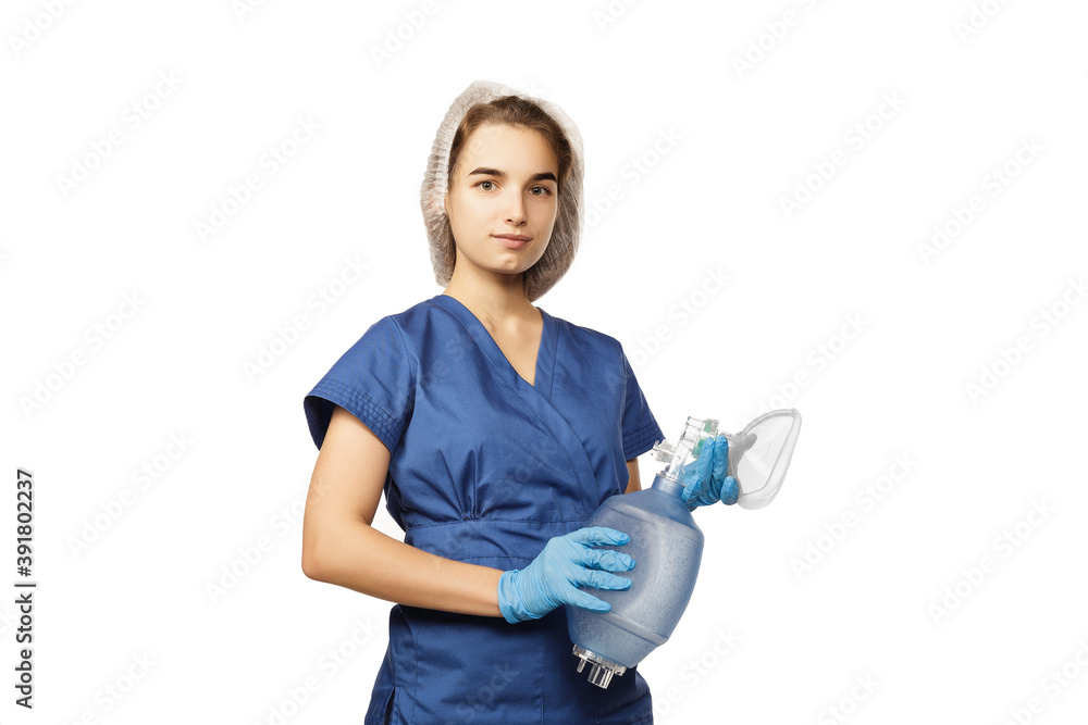 Young beautiful woman doctor in blue surgical gown and gloves holds in hands Am-bu bag for artificial lung ventilation isolated on white background Young beautiful woman doctor in blue surgical gown and gloves holds in hands Am-bu bag for artificial lung ventilation isolated on white background