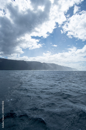 View of a misty Na Pali Coast of the Hawaiian Island  Kaua i from a boat. The coastline got its name from the obvious towering sea cliffs that rise dramatically over the Pacific Ocean.
