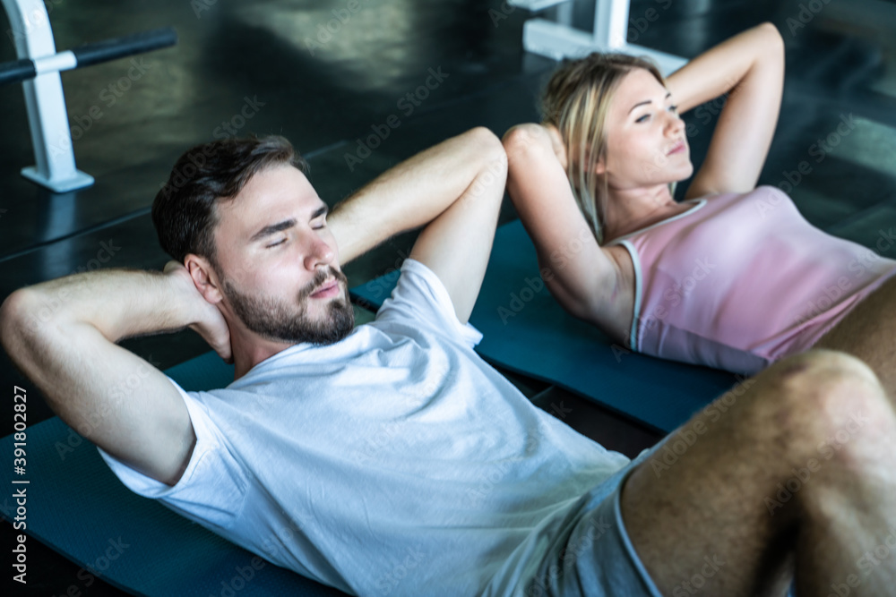 Couple of caucasian sport attractive man and women make sit up crunch exercise Couple of caucasian sport attractive man and women make sit up crunch exercise