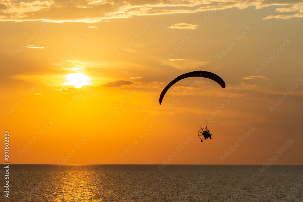 Paragliding. Paraglider flying in the sunset sky Paragliding. Paraglider flying in the sunset sky
