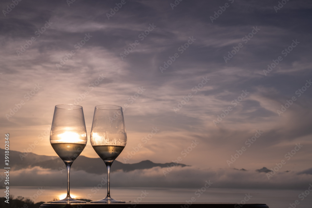 Two glasses of white Wine on a panoramic rooftop at sunset