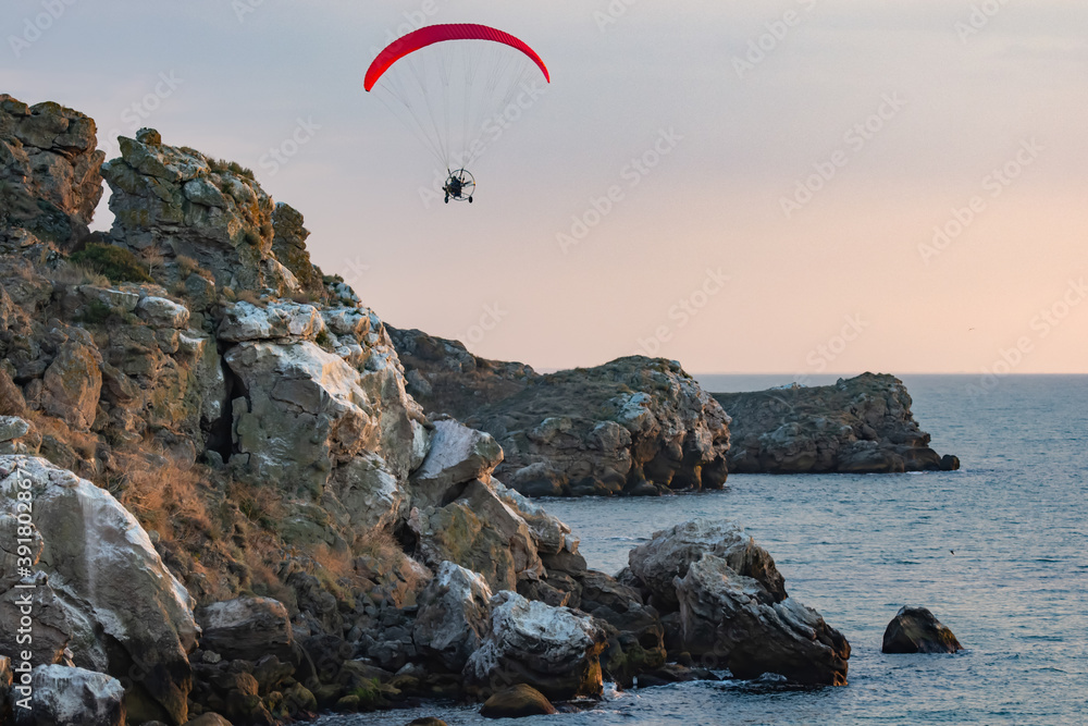 Paragliding. Paraglider flying in the sunset sky Paragliding. Paraglider flying in the sunset sky
