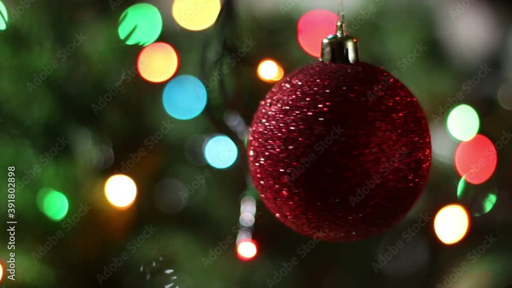 Close-up of a rotating ball on a Christmas tree. Blurred lights background. Close-up of a rotating ball on a Christmas tree. Blurred lights background.