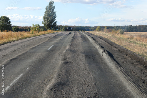 terrible road with longitudinal rut. Poor asphalt surface photo