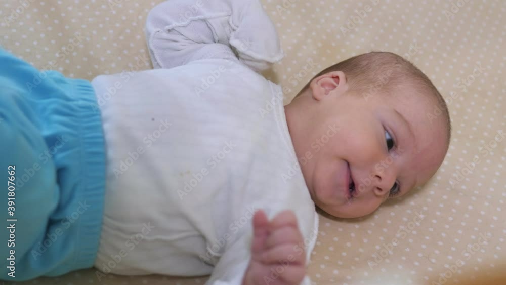 Newborn baby boy lying in bed. Calm cute funny baby wearing pajamas closeup. Naptime Newborn baby boy lying in bed. Calm cute funny baby wearing pajamas closeup. Naptime