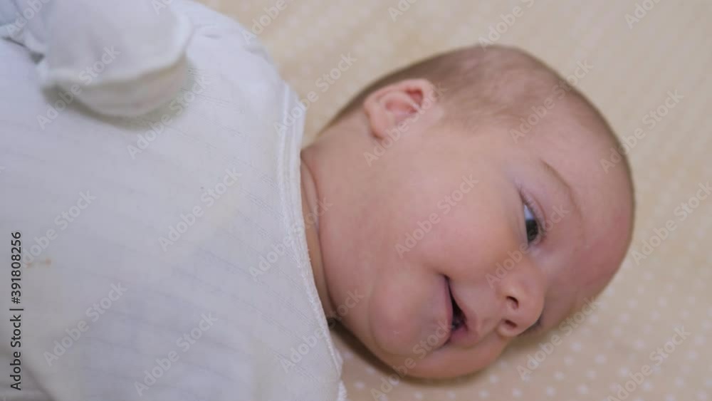 Newborn baby boy lying in bed. Calm cute funny baby wearing pajamas closeup. Naptime Newborn baby boy lying in bed. Calm cute funny baby wearing pajamas closeup. Naptime