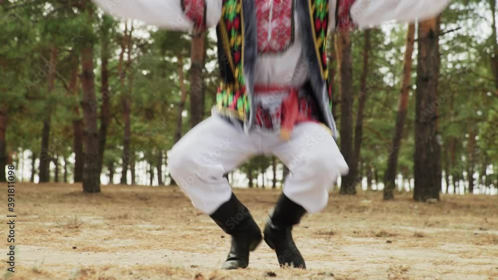 Close up of young man are dancing russian traditional dance in summer forest Close up of young man are dancing russian traditional dance in summer forest