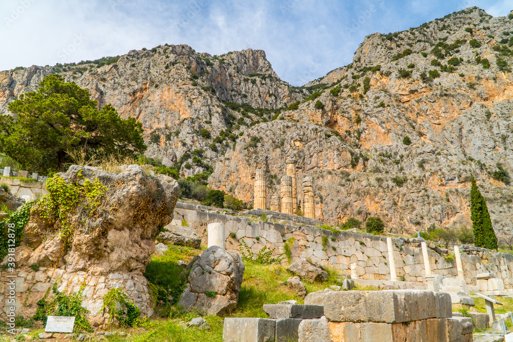 Ruins of the Stoa of Athenians at the ancient ruin site of Delphi, Greece with mountains in the background