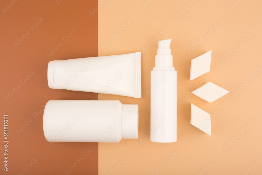 Top view of beauty products for daily skin care and make up sponges for make up application on brown and beige background Top view of beauty products for daily skin care and make up sponges for make up application on brown and beige background