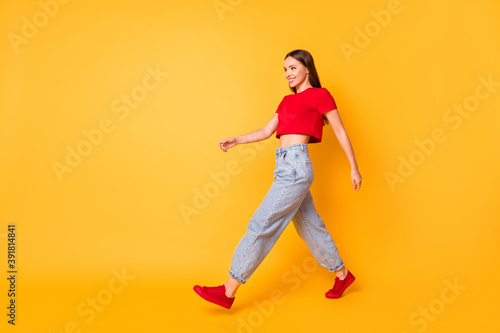 Profile photo of lady traveler walking down street wear red crop top jeans shoes isolated yellow color background