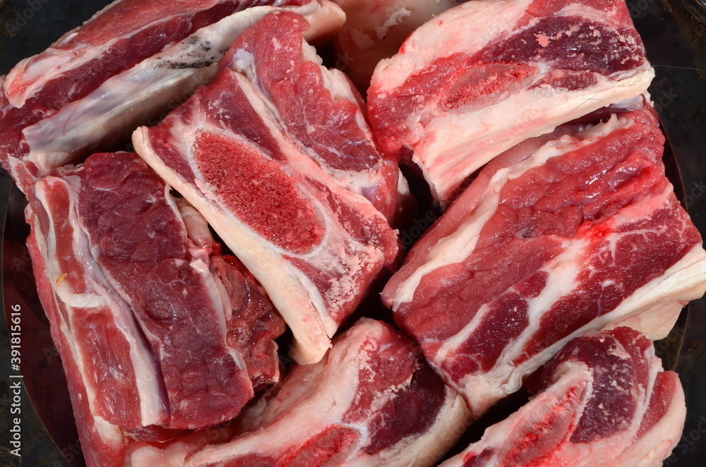 Raw meat ribs on a black silver plate, gray wooden background. Raw Organic Beef Short Ribs Raw meat ribs on a black silver plate, gray wooden background. Raw Organic Beef Short Ribs