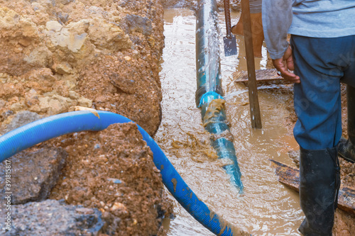 plumber work dig repair water line connect.PVC pipe main plumbing on road and backhoe (water motion)