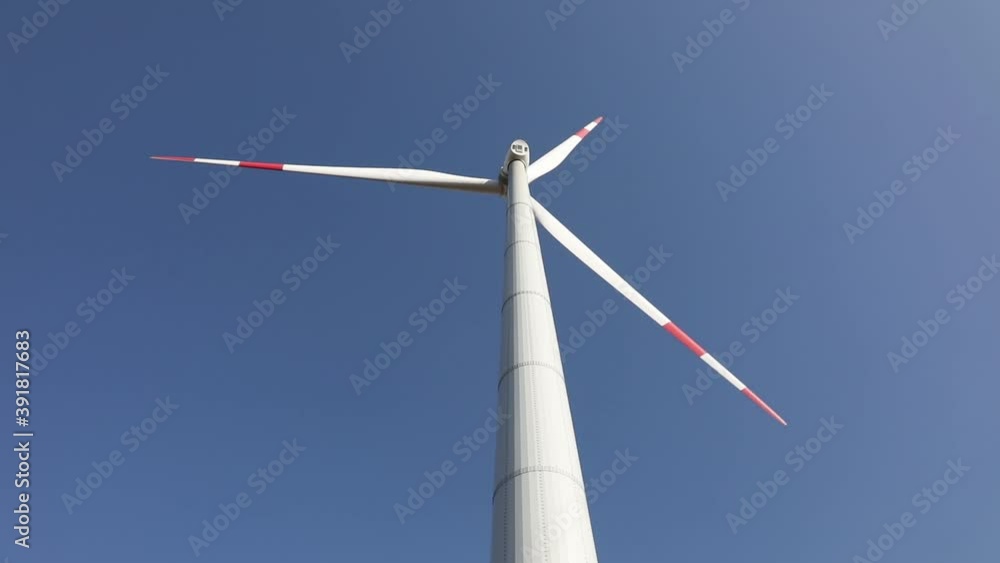 Wind power turbine spinning against a clear blue sky. Renewable Energy in Action
Wind power turbine spinning against a clear blue sky. Renewable Energy in Action