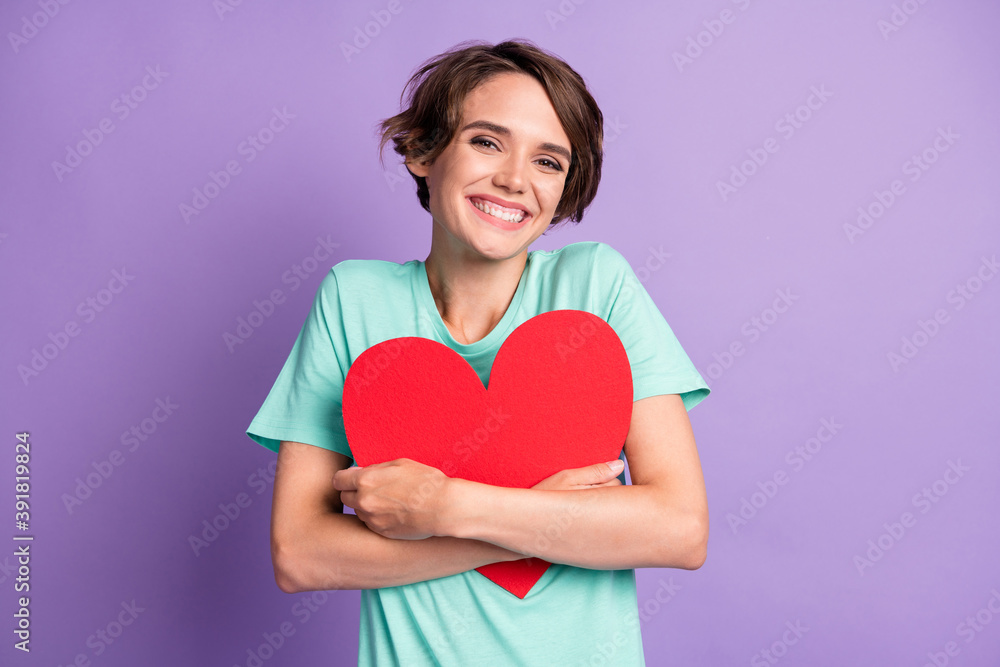 Photo of optimistic nice brown hairdo girl hug paper heart wear blue t-shirt isolated on violet color background Photo of optimistic nice brown hairdo girl hug paper heart wear blue t-shirt isolated on violet color background