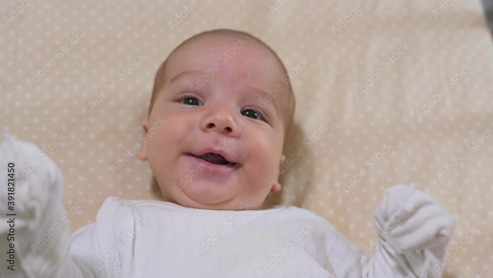 Newborn baby boy lying in bed. Calm cute funny baby wearing pajamas closeup. Naptime Newborn baby boy lying in bed. Calm cute funny baby wearing pajamas closeup. Naptime