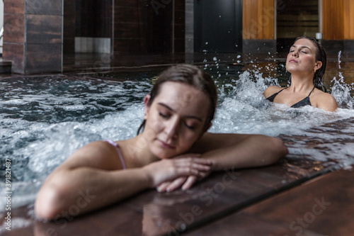 Calm women enjoying spa hydro massage together