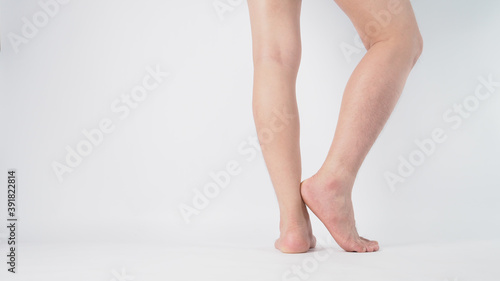 Close up of male barefoot and leg on white background
