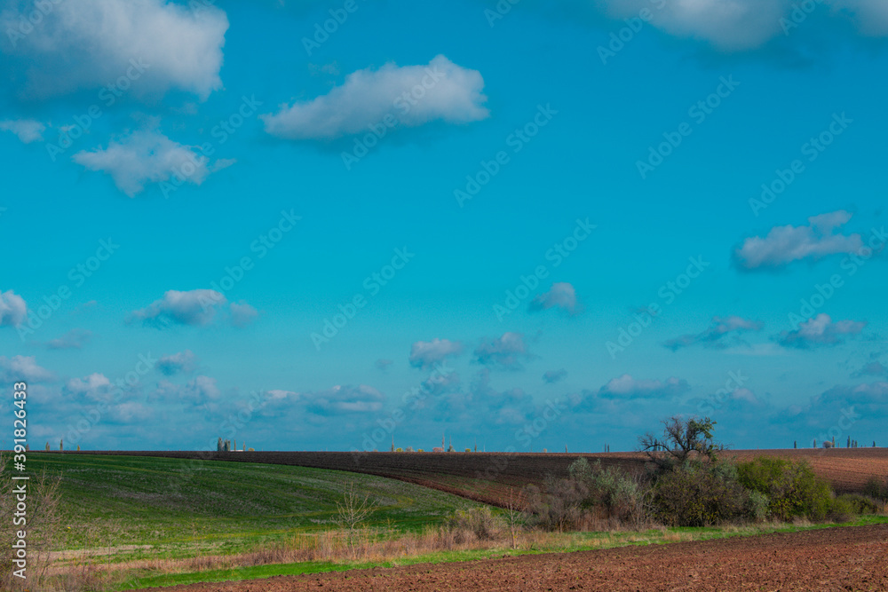 Rural landscape. Fields prepared for growing crops. Landscape with clouds and sky. 