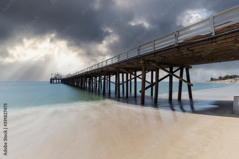 Malibu Pier beach with motion blur and storm sky near Los Angeles in Southern California.  