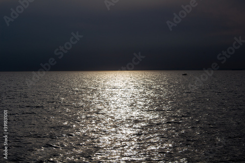 kleines Boot im Sonnenuntergang in der Ferne auf dem Meer
