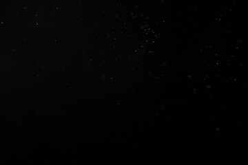 Dust, rain, snow or water spray particles isolated on black background