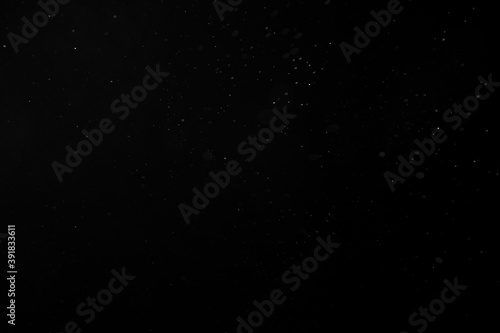 Dust  rain  snow or water spray particles isolated on black background