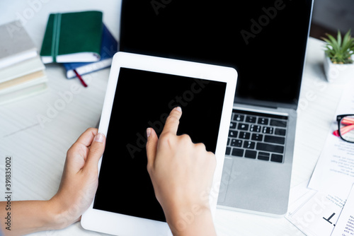 cropped view of woman pointing with finger at digital tablet