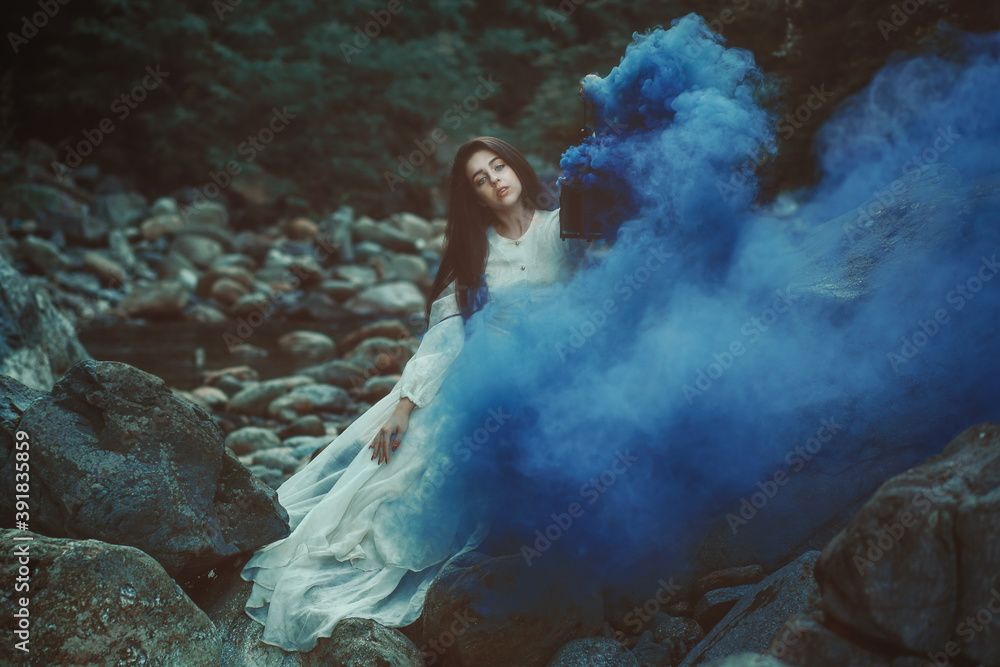 Fototapeta premium Beautiful woman among blue smoke