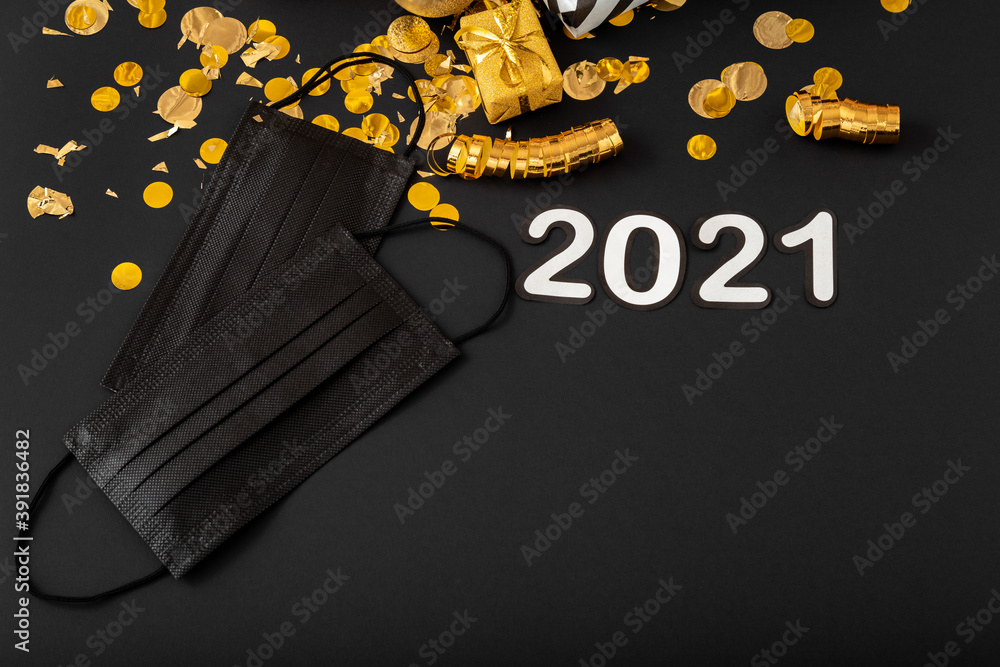 Obraz premium 2021 text lettering with black medical face masks, gold Christmas festive decor. Protective face surgical masks in Celebrating New Year composition covid 19 Coronavirus. Copy space