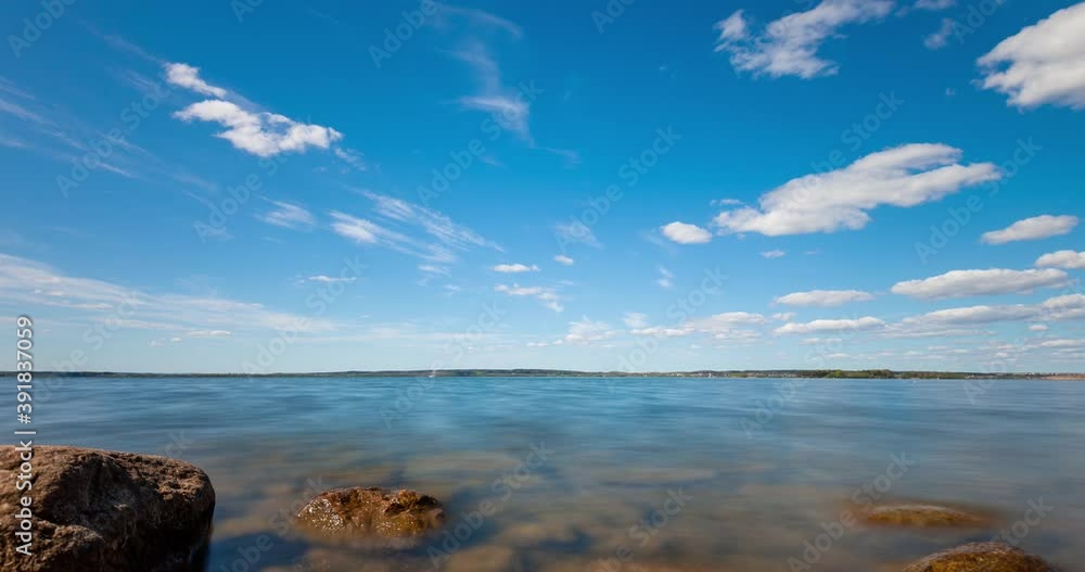 Time lapse of clouds forming over a lake. View through stones in the water. Time lapse of clouds forming over a lake. View through stones in the water.