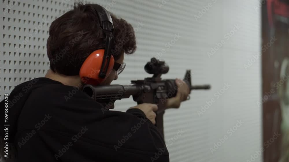 Man Shooting at Firing Range in protective headphones Man Shooting at Firing Range in protective headphones