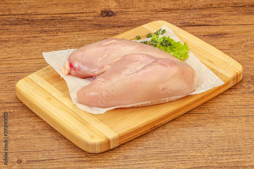 Raw chicken breast over board