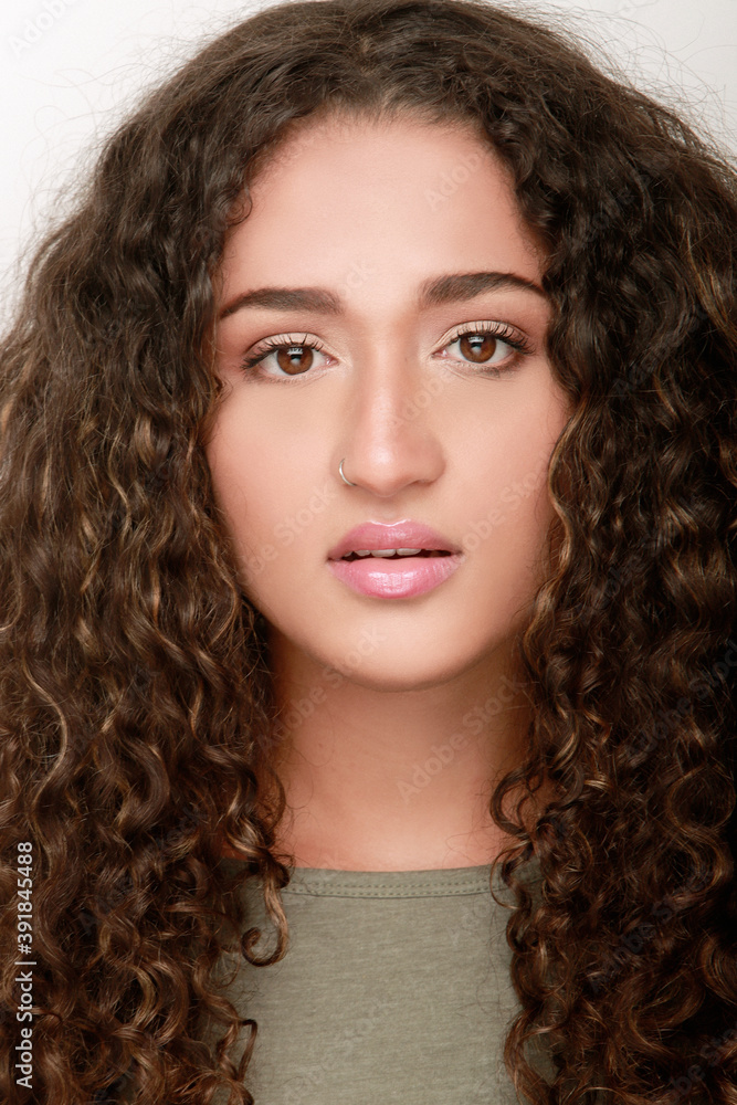 retrato cerca de chica morena latina con pelo rozado largo y expresión seria frente a cámara retrato cerca de chica morena latina con pelo rozado largo y expresión seria frente a cámara