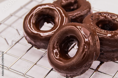 Donuts de chocolate sobre rejilla de metal con fondo blanco