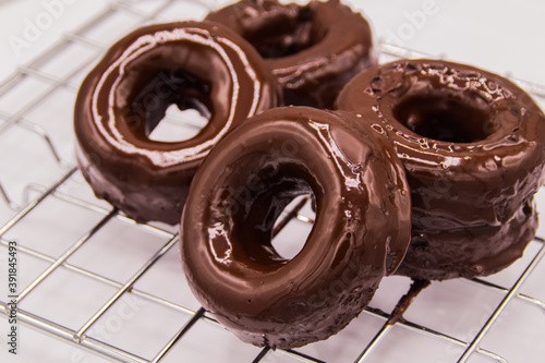 Donuts de chocolate sobre rejilla de metal con fondo blanco