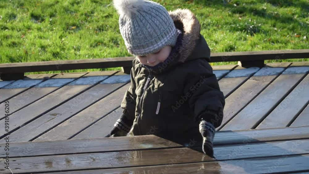 A boy in overalls and a winter hat A boy in overalls and a winter hat