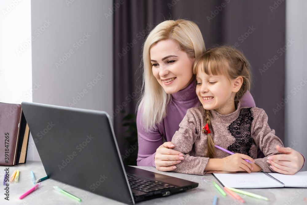 Woman helping young girl with laptop do homework in dining room Woman helping young girl with laptop do homework in dining room
