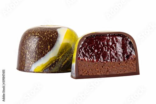 Cut luxury handmade bonbon with chocolate cream and fruit filling isolated on white background