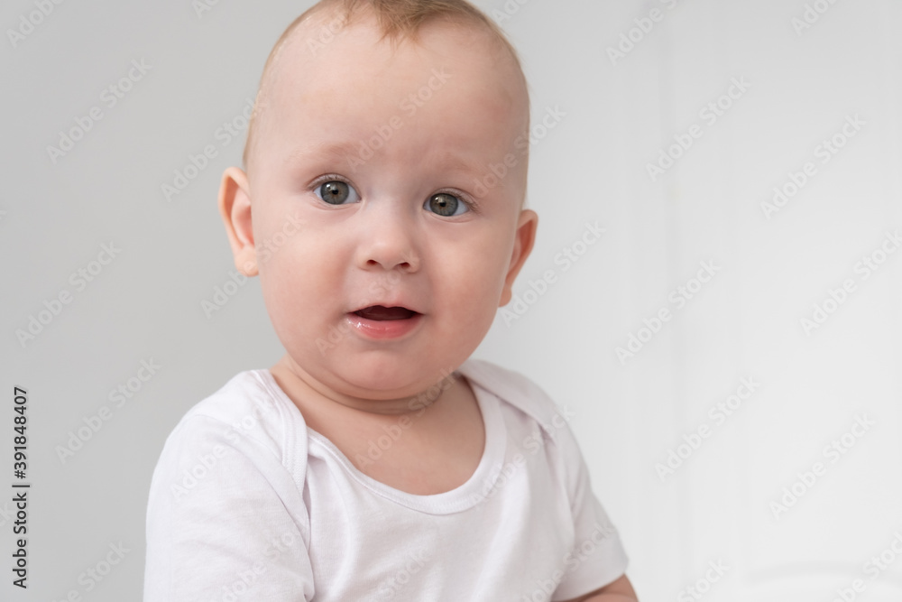 funny baby boy smiling in white bedroom at home. 
