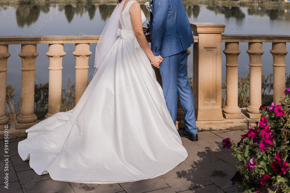 Fototapeta premium bride and groom near the railing on the embankment