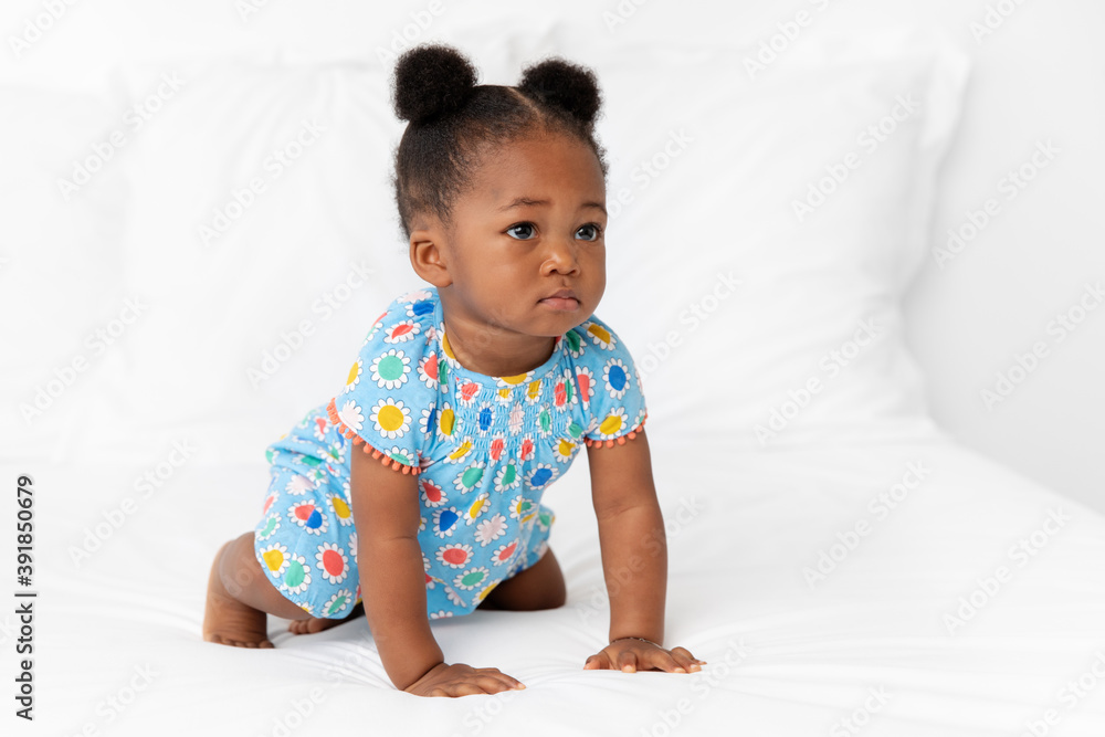 Baby girl with hair buns crawling on bed Baby girl with hair buns crawling on bed