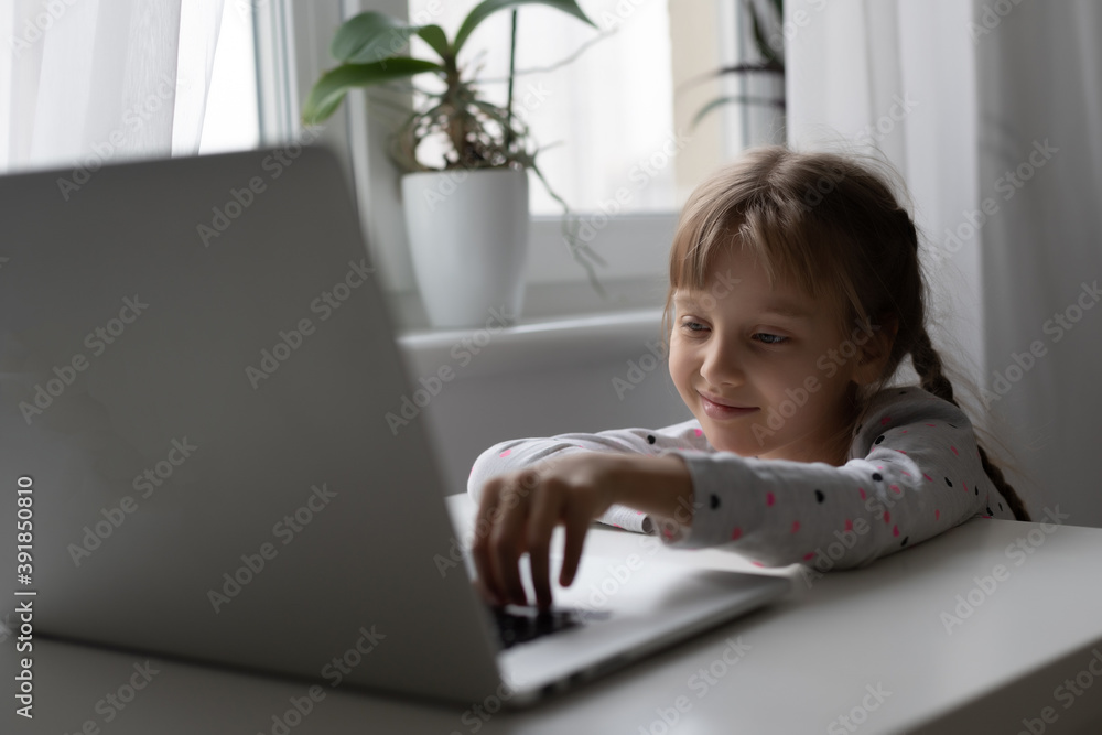 Little girl studying online using her laptop at home Little girl studying online using her laptop at home