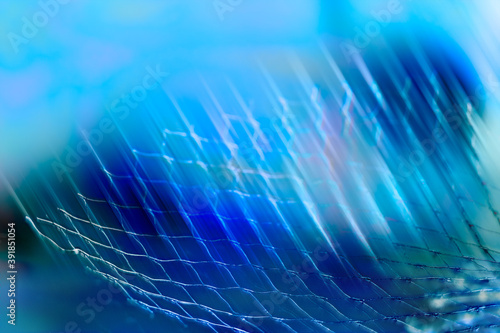 Fotografie Artistic blue toned background with abstract netting detail and light stripes