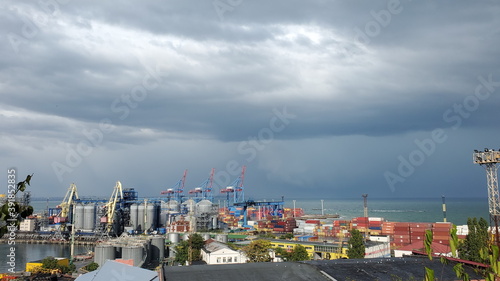 Maritime port landscape with cargo loaders and cloudscape above