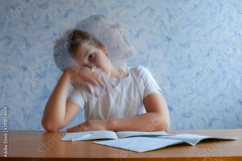 Canvastavla a frustrated boy sits at a Desk with notebooks in front of him turns his head an