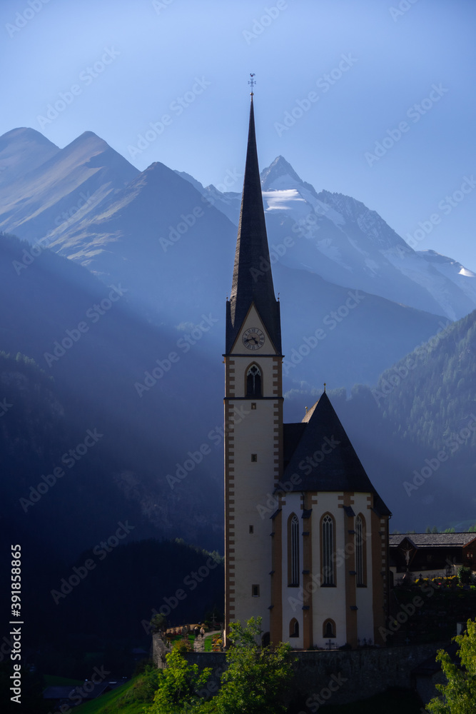 The parish church in Heiligenblut with the Grossglockner in the background in late evening sun