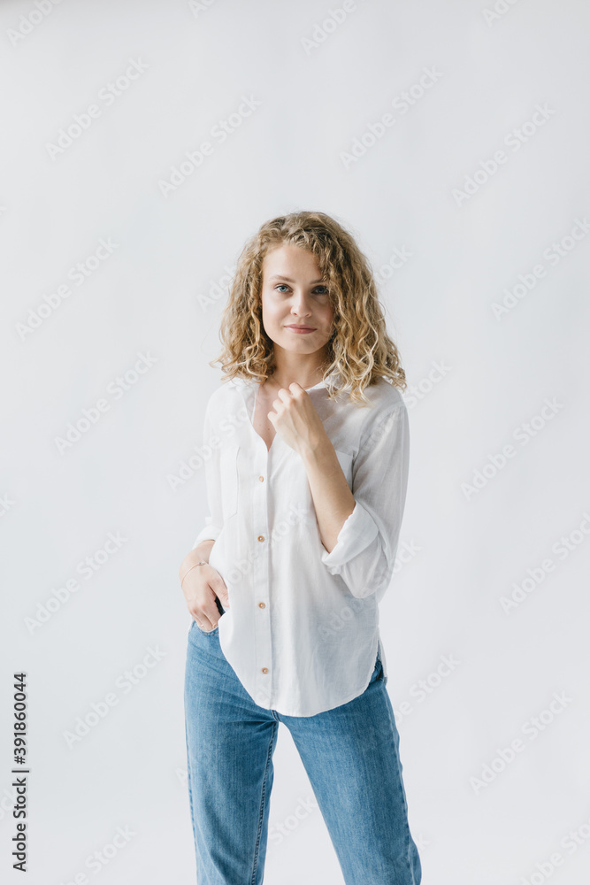 Portrait of a beautiful girl in a white shirt and jeans on a white background. Lifestyle Portrait of a beautiful girl in a white shirt and jeans on a white background. Lifestyle