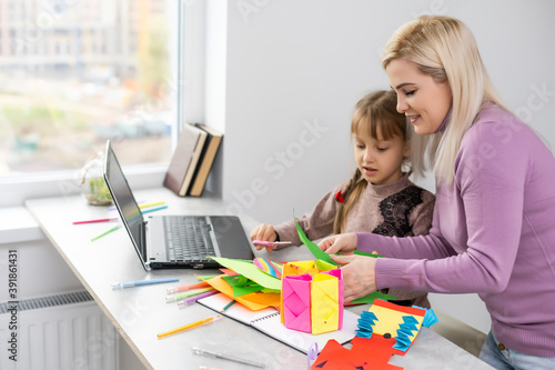 mother and daughter make paper crafts together
