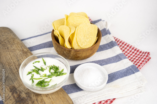 Fototapeta Naklejka Na Ścianę i Meble -  Chips in a wooden bowl with sour cream and green onion.