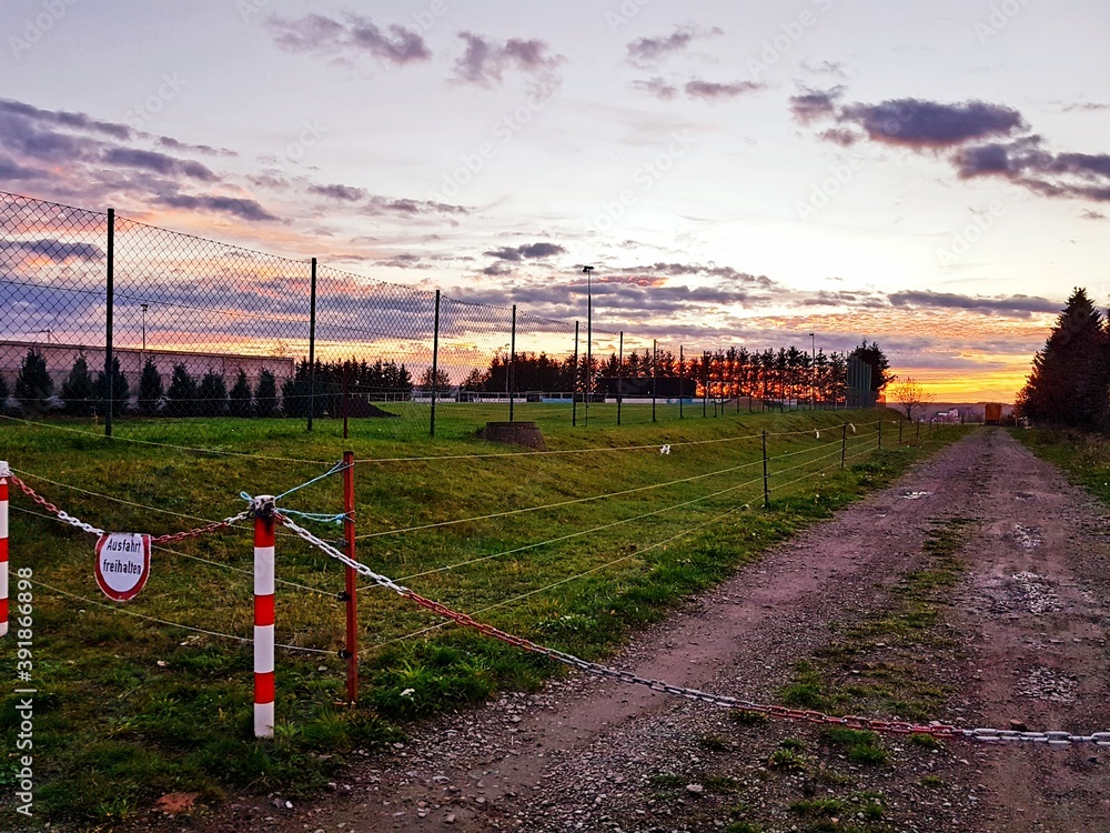 Sportplatz mit Zaun Absperrung bei Dämmerung Sportplatz mit Zaun Absperrung bei Dämmerung
